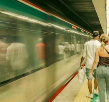 Commuters navigate a bustling subway platform as a train speeds by in İstanbul, Türkiye.