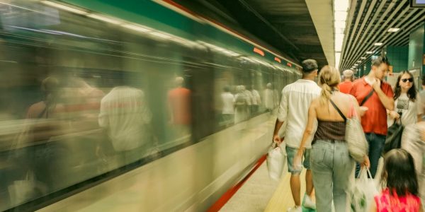 Commuters navigate a bustling subway platform as a train speeds by in İstanbul, Türkiye.